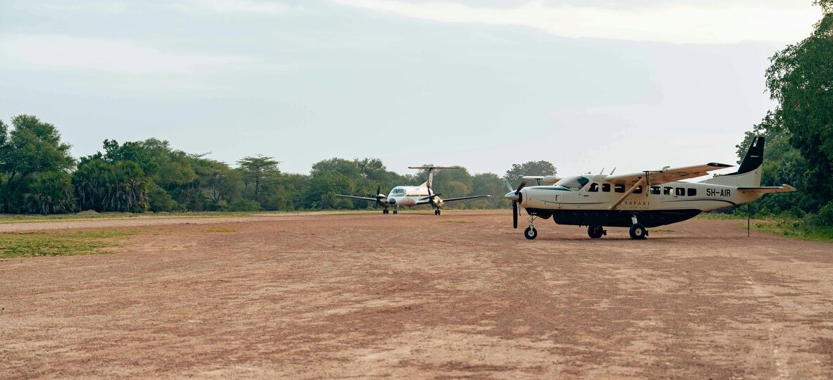 Fly in safari Kenya: light aircraft landing on a bush airstrip in the Masai Mara at sunrise