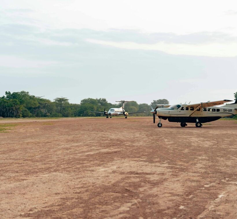 Fly in safari Kenya: light aircraft landing on a bush airstrip in the Masai Mara at sunrise