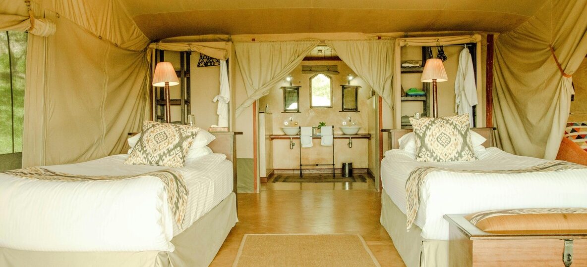 Luxury tented camp suite in Kenya with canvas walls, hardwood floor, plunge pool and elephant herd in background -- Trunktrails Safaris