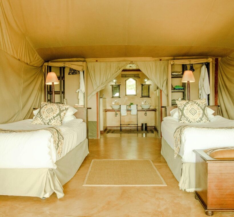 Luxury tented camp suite in Kenya with canvas walls, hardwood floor, plunge pool and elephant herd in background -- Trunktrails Safaris