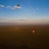 Split image showing wildebeest on the Mara plains at sunrise and a pristine white sand beach with turquoise Indian Ocean water