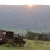 Safari vehicle on a dirt track with elephants and Mount Kilimanjaro in the background at Amboseli National Park