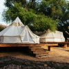 Best Samburu camps Kenya: a tented safari camp on the banks of the Ewaso Nyiro River in Samburu at golden hour, with acacia trees and red-earth hills in the background