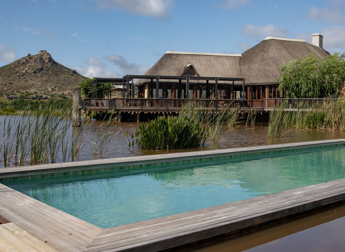 A family-friendly safari lodge swimming pool overlooking the savannah at sunset in Kenya