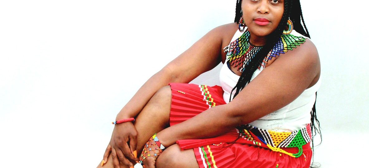 Chui Mamas Laikipia women artisans wearing handmade beaded jewelry near a community center