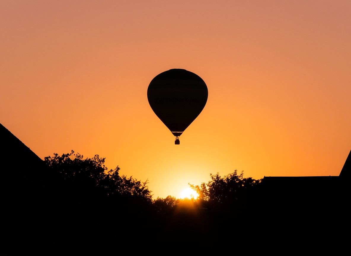 A hot-air balloon drifting over the Maasai Mara plains at sunrise