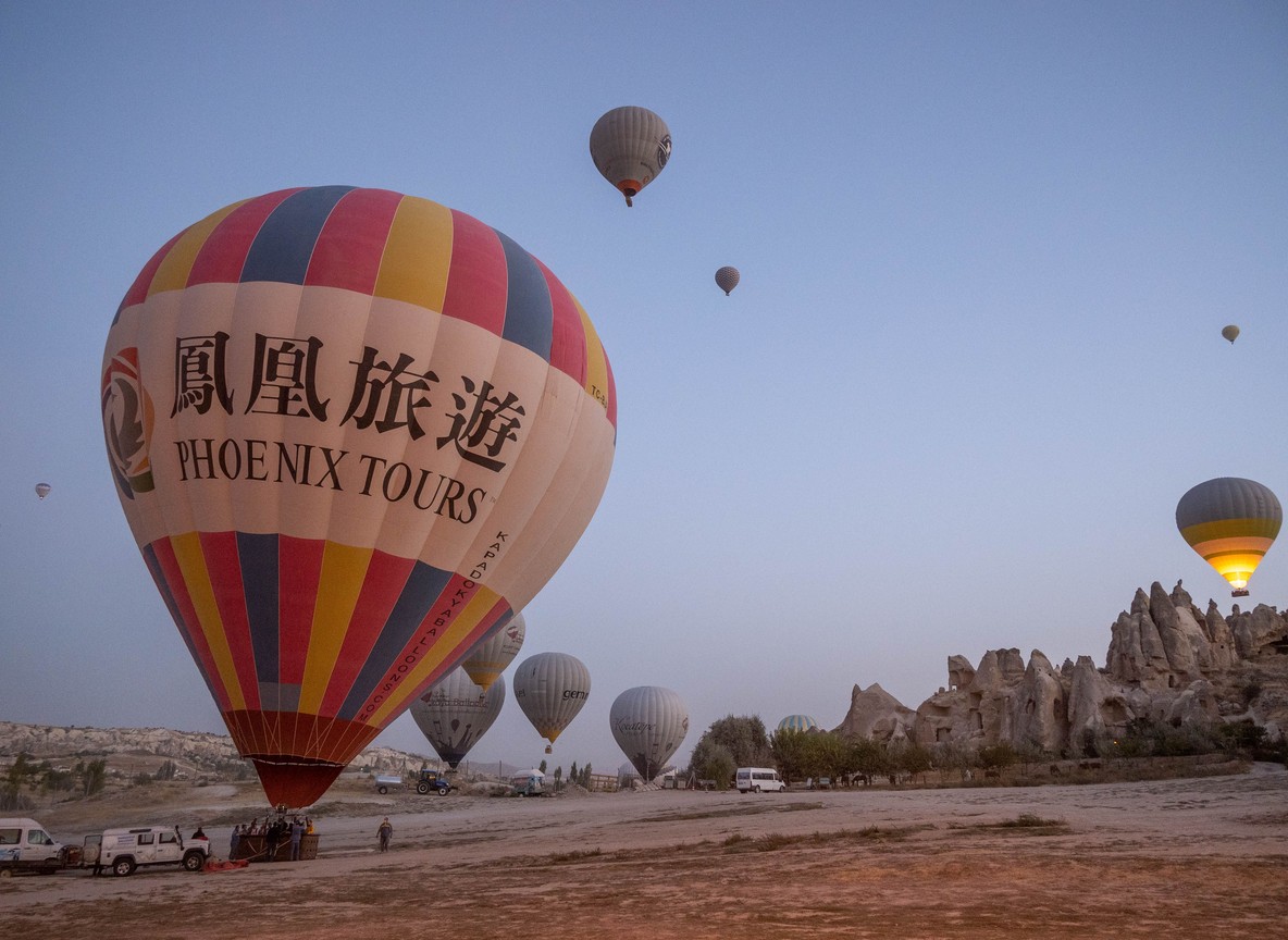 A hot air balloon drifting over the Masai Mara plains at sunrise