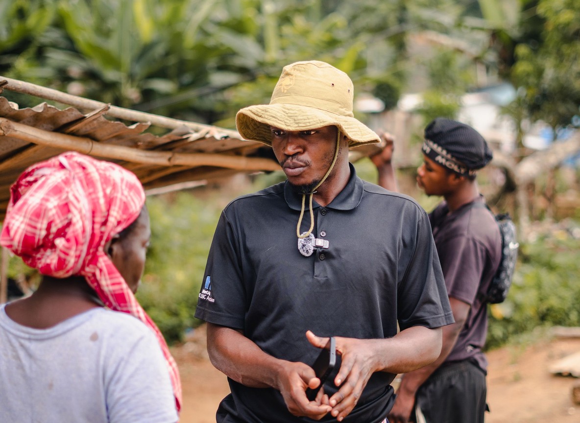 Trunktrails guide pointing out a chimpanzee enclosure feature to guests on a raised viewing platform