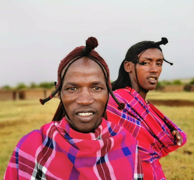 Maasai warriors in traditional red shukas performing the adumu jump dance during a cultural festival celebration in Kenya