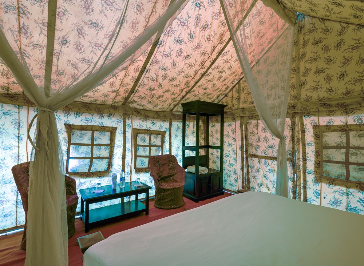 A luxury tented suite interior at a Laikipia conservancy camp overlooking open grassland