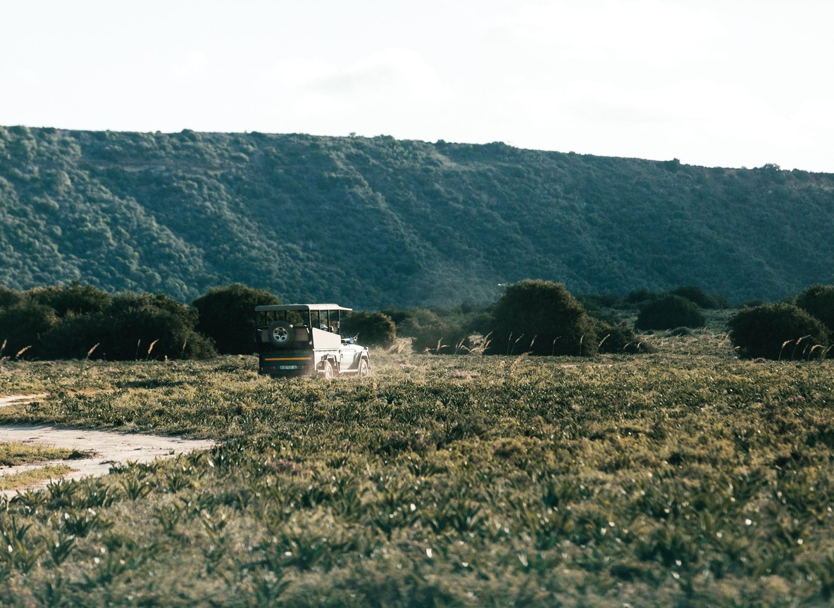 Safari vehicle driving along the Rift Valley escarpment road between Nakuru and Narok