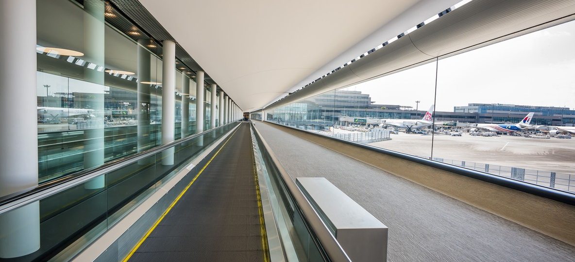 Jomo Kenyatta International Airport terminal exterior with a safari vehicle waiting at the arrivals curb