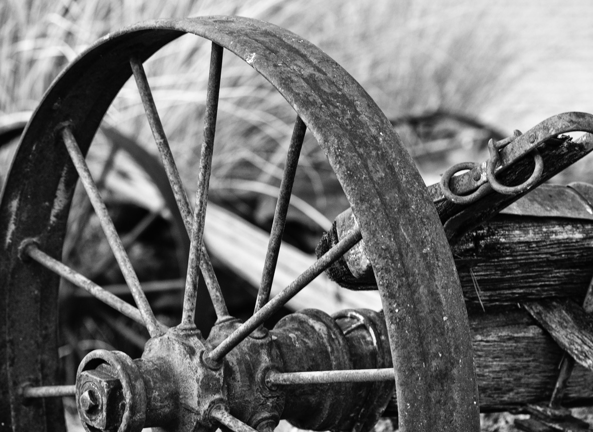 Close-up detail of an old railway wheel and wooden carriage frame in a museum collection