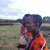 A young child and parent watching giraffes from a safari vehicle in Kenya