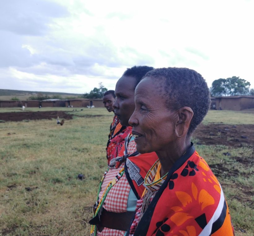 A young child and parent watching giraffes from a safari vehicle in Kenya