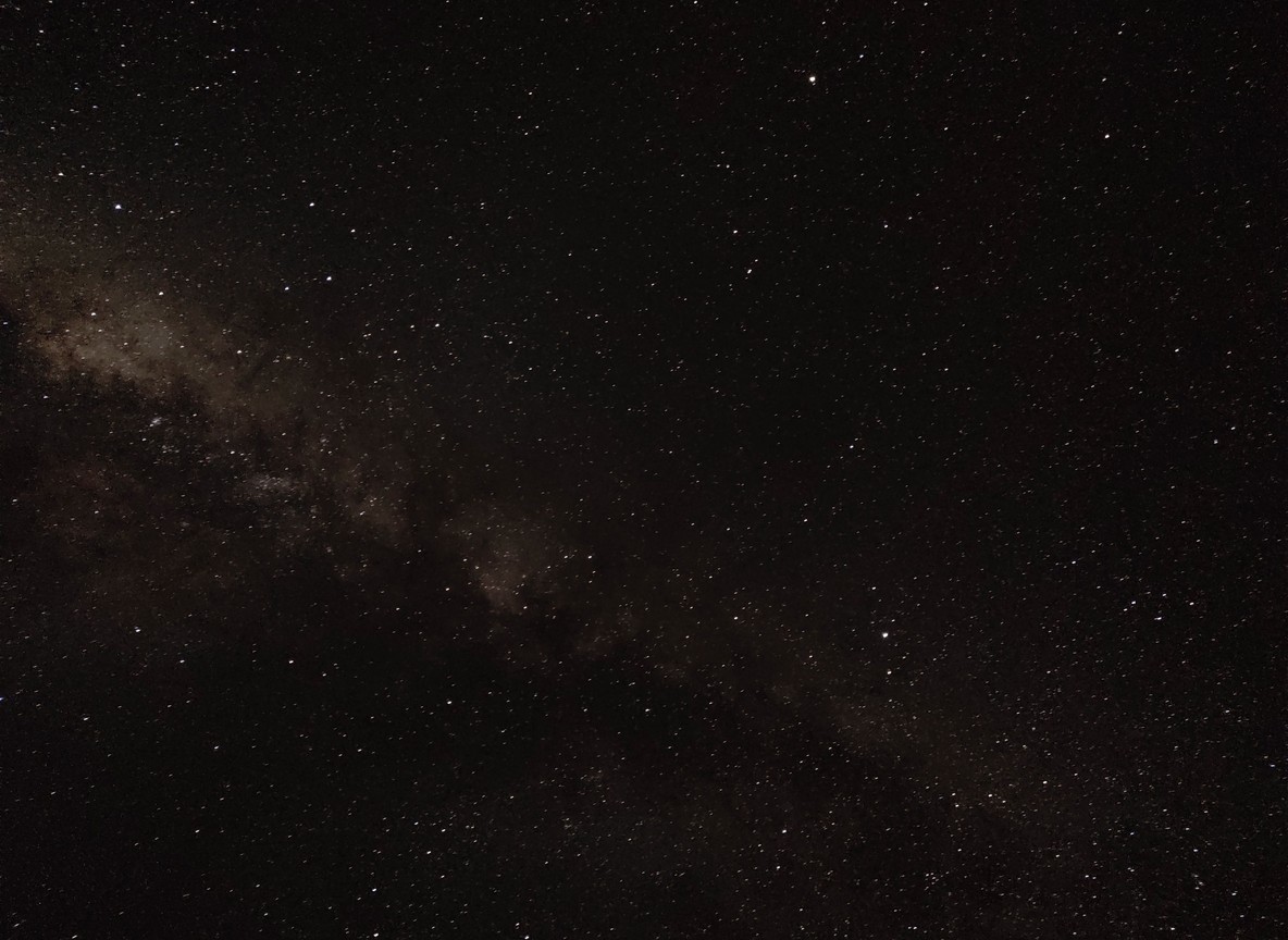 The Milky Way stretching across a clear night sky above silhouetted trees on the Laikipia Plateau