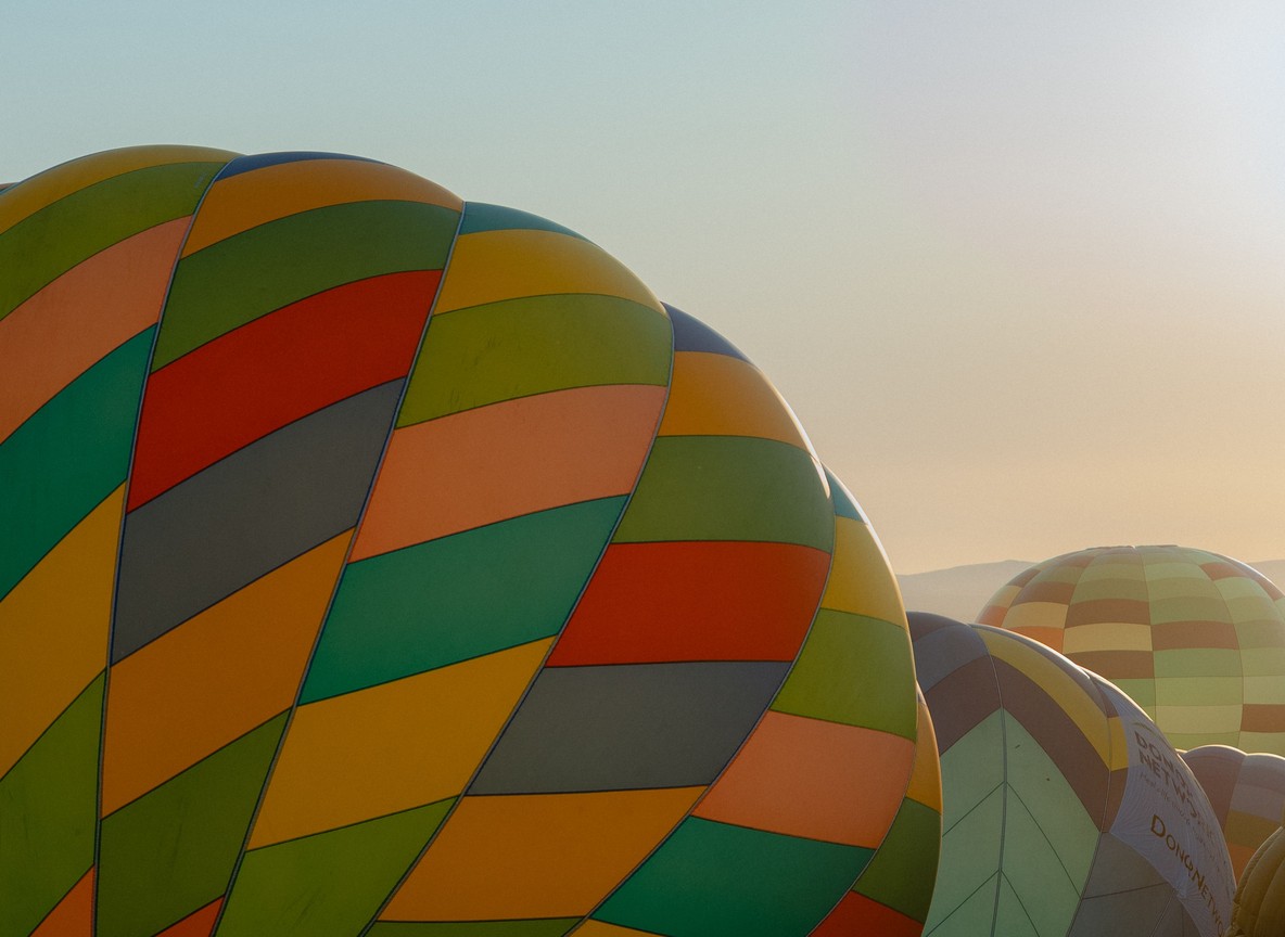 A hot-air balloon drifting over the Masai Mara plains at sunrise