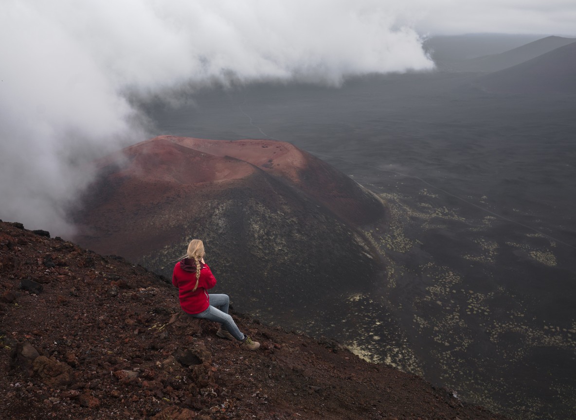 A dormant volcanic crater rim trail with a hiker's path visible against a blue sky in Kenya's Rift Valley
